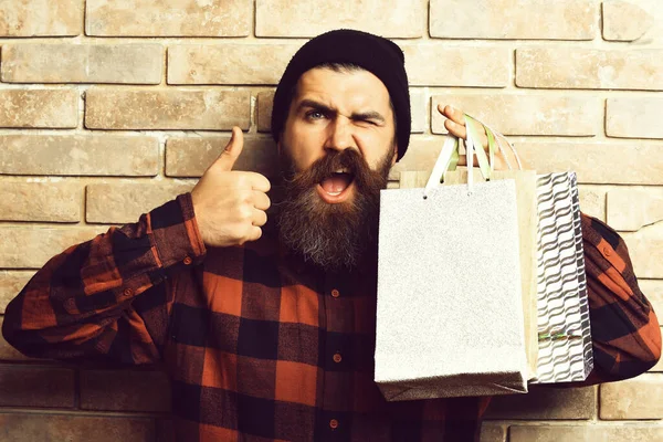 Bärtiger brutaler kaukasischer Hipster mit Schnurrbart hält Einkaufspakete in der Hand — Stockfoto