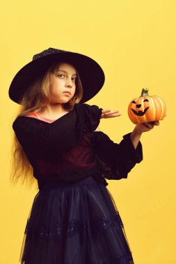 Cadı kostümü giymiş çocuk ve Jack O Lantern.