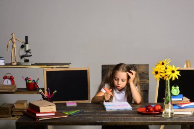 Liseli kız konuşur ve resimlerini çizer. Masadaki kız.