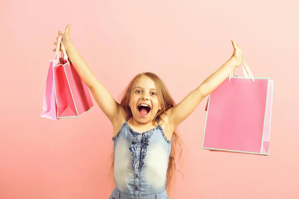 School meisje met pakketten geïsoleerd op roze achtergrond — Stockfoto