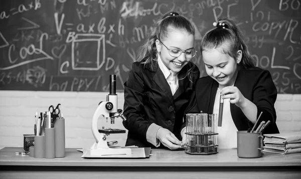 Basic knowledge of chemistry. Make studying chemistry interesting. Pupils cute girls use test tubes with liquids. Chemistry experiment concept. Safety measures for providing safe chemical reaction