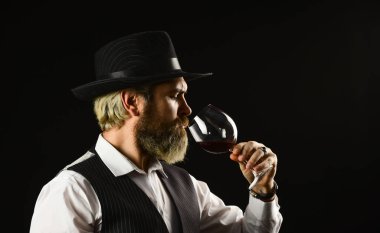 Alkol içeceği. Zarif garson kırmızı şarap içer. Şarap mahzeninde çalışıyorum. Bar ya da şaraphane. Şarap arıtma. Zarif takım elbiseli sakallı iş adamı ve bir kadeh şarap. Sommelier 'in pahalı bir içeceği var.