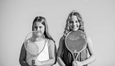 Eğitimden sonra dinleniyorum. Açık hava oyunları. Tenis oyna. çocukluk mutluluğu. Tenis raketli küçük kızlar. Yaz sporları aktivitesi. Enerjik çocuklar. Mutlu ve neşeli. spor oyunu oynanıyor