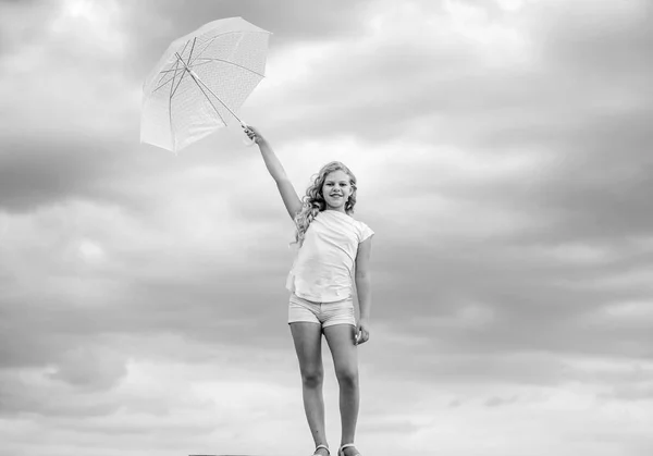 屋外で気をつけて。天気予報。どんな天気でもいいです。天気が変わる。新鮮な空気だ。傘の曇った空の背景を持つ女の子。自由と新鮮さ。反重力の概念。楽しみ方 — ストック写真