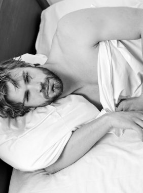 Tembel adam mutlu uyanıyor ve sabah elleri kalkıyor. Rahatlamış hissediyor. Rahat bir yatakta uyuyan bir adamın ayakları. Çekici genç adam yatakta dinleniyor..