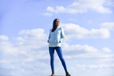 Bulutların üstünde. Uzaklara bakmak, özgürlük duygusu. Gelecek ve başarı. Yaşam tarzı konsepti. Gündelik ceketli modaya uygun bir kız. Sonbahar ve bahar tarzı. Gökyüzü arka planında genç ve güzel bir kadın