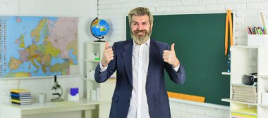 Faiziyle öğretiyor. Başarılan öğrenme sonuçlarını doğrula. Öğretmenlik dersi. Eğitim ve eğitim. Modern okul. Bilgi toplama günü. Okula dönelim. Sınıfta duygusal sakallı bir adam var.