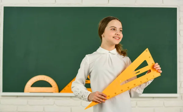 Meisje klaar om te studeren. Studenten meisje op school. Wiskunde studeren met driehoek. Een kind van de basisschool. Leerlingstudie met geometrisch gereedschap. Terug naar school. Een jongen met apparatuur. meten en tellen — Stockfoto