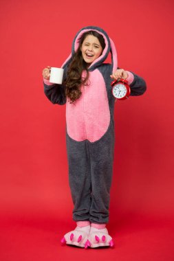 Kahve enerjisi içiyorum. Sana da günaydın. Küçük kız Paskalya tavşanı kostümü giyiyor. Bir fincan kahveyle erken kalkarım. Kigurumi pijamalı esneyen çocuk çalar saat tutuyor. Uyanma zamanı. Çok erken.