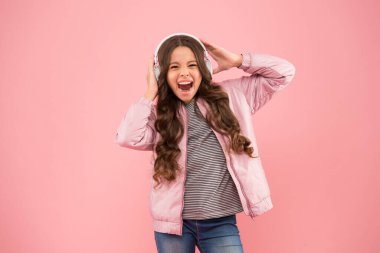 Kendini çok mutlu hissediyor. Duygusal bir şarkıcı. Kulaklıkla çalan eğlenceli şarkı. Karaoke ve eğlence. Bir şarkıya katılıyorum. Küçük kız pembe arka planda şarkı söylüyor. Küçük çocuk şarkı söylüyor.