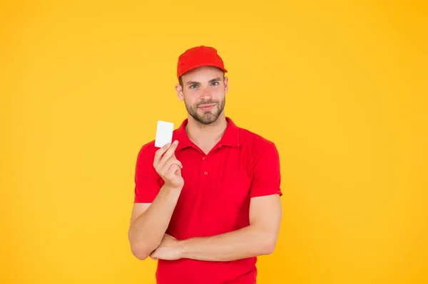 Inscription des contacts. Livreur de personne. Livreur en uniforme rouge. Employé masculin en bonnet et tshirt. traiter et acquérir le paiement par carte. paiement de la livraison par carte de crédit. Carte de fidélité — Photo