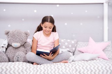 Oku bana. Küçük kız oyuncak ayıya masal okuyor. Küçük çocuk çocuk çocuk odasında kitap okuyor. Edebiyat ve kütüphane. Sadece güzel bir uyku zamanı okumak istiyorum. Çocuk gelişimi. Okuma yoluyla hayal gücünü geliştirmek
