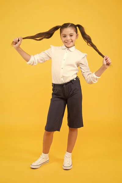 Playing with hair. Schoolgirl happy smiling pupil long hair. Beginning of academic year. Adorable schoolgirl. Time to study. Ready for lesson. School fashion. Hair care concept. Playful schoolgirl — Stock Photo, Image