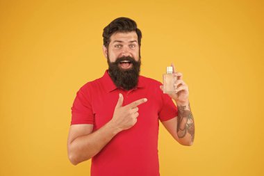 Parfüm seç. Losyon spreyi. Parfüm ürünleri konsepti. Sakallı, yakışıklı adam şişe parfümü kullanıyor. Parfüm sürmüş. Misk aromatik madde genellikle temel notada kullanılır.