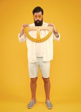 Okula ve matematiğe geri dönelim. Okul öğretmeni sarı arka planda ölçüm aletleri tutuyor. Sakallı adam okul dersi için protractor hazırlanıyor. Okulda öğrenme veya öğretme boyutu