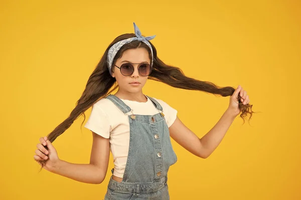 Haare so stark. fröhliches kleines Mädchen gelbe Wand. retro Kind lange Haare. Kleines Mädchen mit Sonnenbrille und Kopftuch. Frohe Sommerferien. UV-Schutz. Sommer-Accessoires. Frühjahrskindermode — Stockfoto