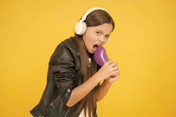 Enfrenta a música. a cantar karaoke. casaco de couro cantor. criança ouvir música rock. rádio escolar dj. hipster menina estilo urbano. Um miúdo com auscultadores. menina pequena cantar música favorita. Imagina que és uma estrela pop. — Fotografia de Stock