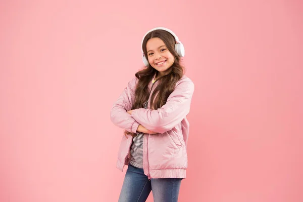 Enjoy sound. Sound vibrations. Music and technology. Audio sound. Singing along to tune. Happy child enjoy listening to sound track. Little girl wear earphones pink background