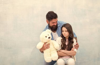 Şu oyuncağa bak. Baba, küçük kızına yumuşak oyuncağını göster. Üzgün çocuk ve oyuncak ayılı sakallı adam. Oyun ve oyun. Oyuncak dükkanı. Çocuksu kal, boşluğu kopyala