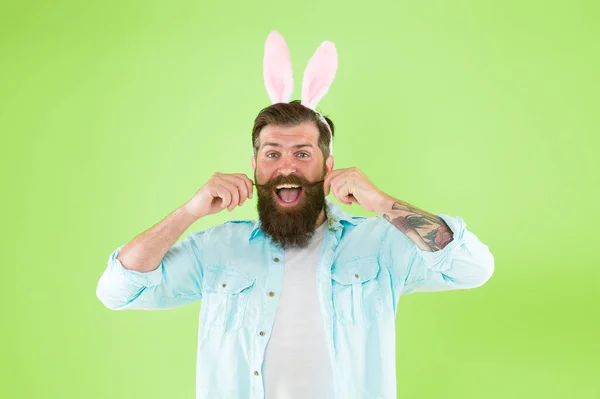 Deixa crescer o cabelo. Homem barbudo usar orelhas de coelho fundo verde. Hipster com pêlos faciais em estilo Páscoa. Bigode de guiador. Salão de cabeleireiro. Barbearia. Mantenha o cabelo fora da boca — Fotografia de Stock