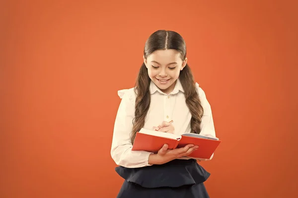 La colegiala disfruta del estudio. El uniforme de la escuela para niños tiene libro de ejercicios. Lección escolar. Niño haciendo la tarea. Tu carrera comienza aquí. Escribe ensayo o notas. Inspiración para el estudio. De vuelta a la escuela. Día del conocimiento — Foto de Stock