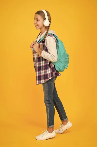 Ontdek de mogelijkheden. hipster meisje zorg rugzak. schooltas voor schoolmeisjes. Herfst kindermode. kind luister muziek headset. onderwijs en ontwikkeling van kinderen. Gelukkige kinderdag. audioboek — Stockfoto