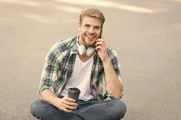 Relax and recharge. Have fun during break. Call friend. Guy carefree student enjoy coffee outdoors. Life balance. Wellbeing and health. Having coffee break. Man sit on ground while drinking coffee — Stock Photo, Image