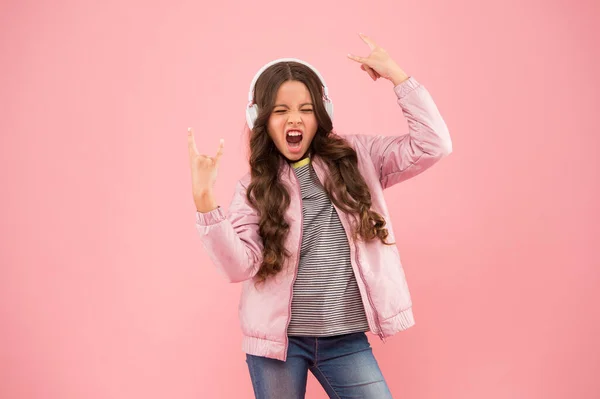 Feel like a winner. Small girl sing to song pink background. Little child do vocal on song. Emotional singer. Enjoying song playing in headphones. Karaoke and entertainment. Joining in a song — Stock Photo, Image