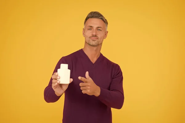 Ayudar a tomar una mejor decisión de compra. Un hombre guapo señala con el dedo la botella. Producto publicitario. Perfume publicitario. Anuncio. Promoción y publicidad. Publicidad de fragancias, espacio para copias — Foto de Stock