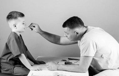Eksiksiz sağlık. Sağlık sigortası. Babası steteskoplu mutlu bir çocuk. Baba oğul tıp üniforması giyiyorlar. Babasıyla oynayan küçük bir çocuk. Çocuk doktoru stajyeri. Hemşire laboratuvar asistanı. Aile doktoru