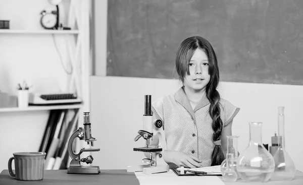 Mikroskobu olan küçük bir kız. Bilimsel deney. Büyüleyici bir ders. Mikrobiyolojiyi araştır. Biyoloji okuyorum. Biyoloji eğitimi. Kız biyoloji sınıfı test tüpleri. Fen dersi. Okul laboratuvarı — Stok fotoğraf