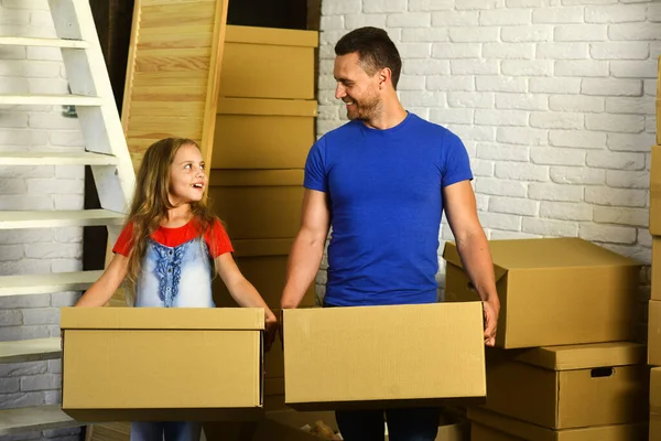 Daughter and father hold boxes and unpack or pack.