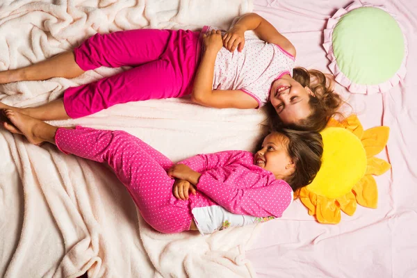 Kinderen in roze pyjama zetten hoofden bij elkaar. — Stockfoto