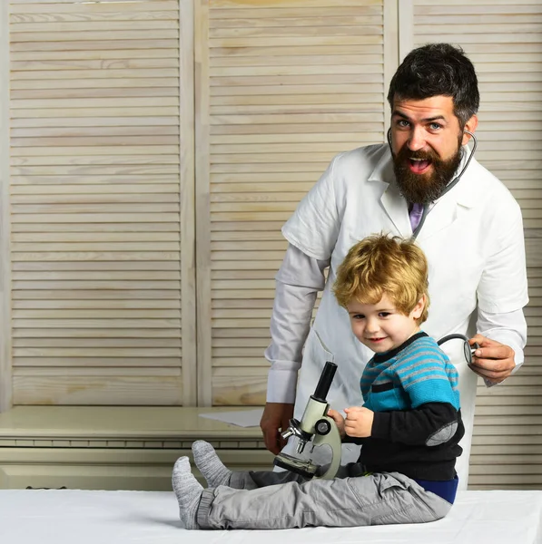 Pediatra y ayudante cerca del microscopio. Salud y concepto infantil . — Foto de Stock