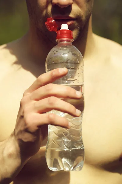 Homme assoiffé avec barbe et poitrine nue tient bouteille d'eau — Photo