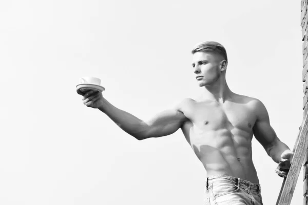 Hombre sosteniendo la taza de café en el fondo del cielo, cara seria —  Fotos de Stock