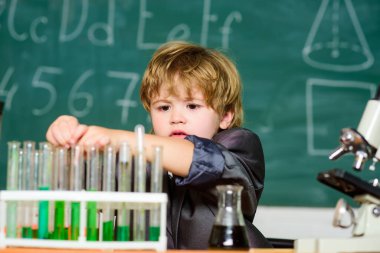 Laboratuvar önlüklü çocuk kimya öğreniyor. Kimya laboratuvarı. Okula dönelim. Okulun laboratuarında kimyasal deneyler yapan küçük bir çocuk. Parlak zekalar iş başında