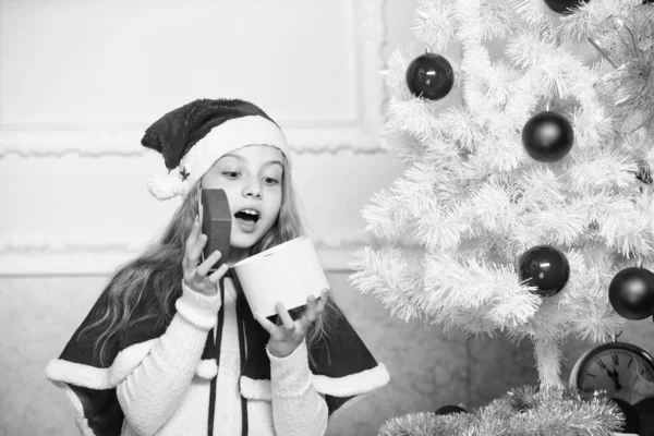 Grabben med julklapp. Förnuftiga barn älskar julen. Flickan firar jul öppna presentförpackning. Tomten kommer med sin gåva. Packa upp julklappen. Gissa vad som finns inuti lådan. Vintersemester tradition — Stockfoto