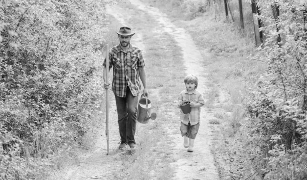 Bu benim hayatım. mutlu dünya günü. Aile ağacı emzirme. çiftlikte kovboy şapkalı baba ve oğul. Eko çiftliği. sulama olabilir, pot ve kürek. Bahçe Ekipmanları. küçük çocuk çocuk çiftçi yardım baba — Stok fotoğraf