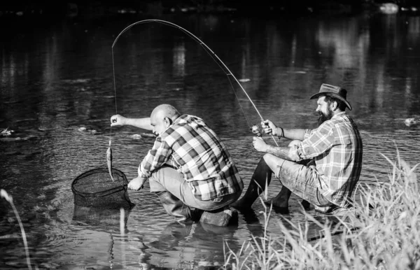 Trap for fish. Men sit at riverside with fishing equipment. Illegal hunting caviar. Extracts eggs from sturgeon caught river. Poaching crime and fishing license. Black market caviar. Poachers fishing — Stock Photo, Image