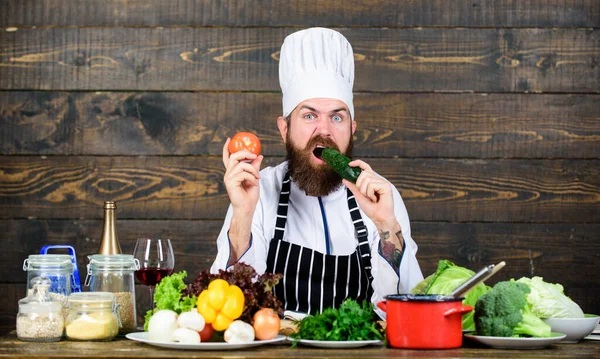 Honger en eetlust. Gezond vegetarisch recept. Man bebaarde hipster hoed en schort koken gezond voedsel. Vegetarische levensstijl. Kok bereiden heerlijke maaltijd houten achtergrond. Verliefd op gezond voedsel — Stockfoto