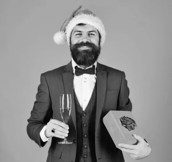 Gerente con barba sostiene copa de champán y regalo. —  Fotos de Stock
