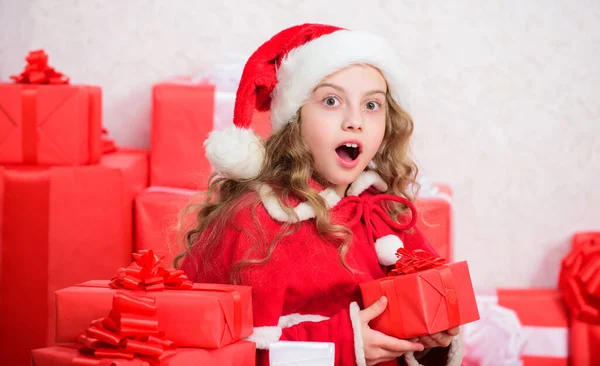 A rapariga celebra o Natal. O Pai Natal traz o presente dela. Conceito de felicidade de inverno. Explore presentes de Natal. Desembalar presente de Natal. Tradição de férias de Ano Novo. Kid animado sobre a abertura presente de Natal — Fotografia de Stock