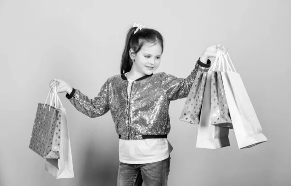 Detaljhandel. Semester köp spara. Glada barn. En liten flicka med gåva. Försäljningsrabatter. Mode och stil. kund med förpackning. En liten flicka med shoppingväskor. Definitivt måste. Måste ha gjort det. det är ett måste — Stockfoto