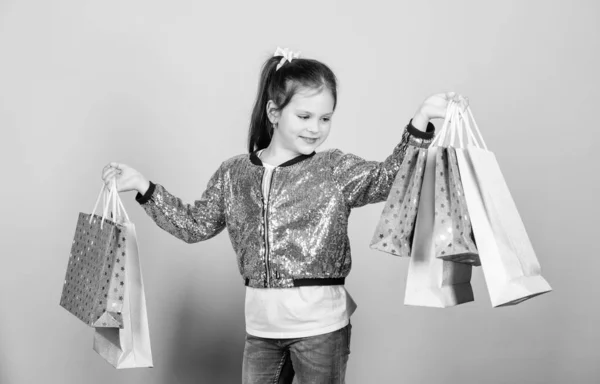 Al por menor. Ahorro de compra vacaciones. Niña alegre. Niña con regalo. Descuentos de ventas. Moda y estilo. cliente con paquete. Niña pequeña con bolsas de compras. Definitivamente debe. debe haberlo hecho. es una necesidad — Foto de Stock