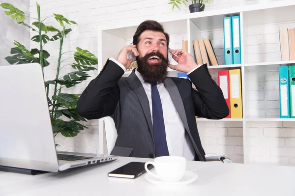 Stay happy. Businessman listen to music at workplace. Businessman wear headphones in office. Bearded businessman relax during work break. Music. Entertainment. Relaxation. Enjoy life