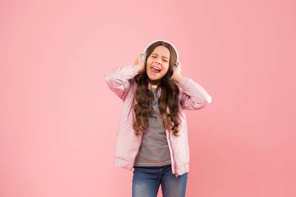 On se joint à une chanson. Petite fille chanter à fond rose chanson. Le petit enfant fait du chant sur la chanson. Chanteuse émotionnelle. Profiter de chanson jouant dans les écouteurs. Karaoké et divertissement. Chanter pour accorder — Photo