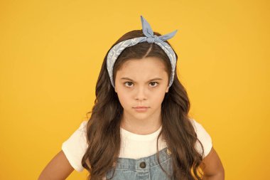 Retro çocuk sarı arka plan. Küçük kız klasiği. Yazlık çocuk modası. Güzellik ve moda. Mutlu çocukluk. Kuaförden sonra üzgün. Uzun kıvırcık saçlı, küçük bir güzellik.