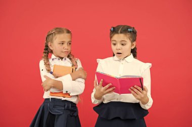 Kırtasiyeye takıntısı olan kızlar. Çocukların okul üniformaları kitabını tutuyor. Okul kızı şov günlüğü defteri. Okul malzemeleri konsepti. Okul kırtasiyesi. Ders çalışmak için şirin kırtasiye malzemeleri al.