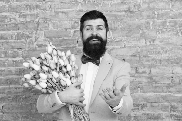 Macho getting ready romantic date. Tulips for sweetheart. Romantic gift. Man well groomed tuxedo bow tie hold flowers bouquet. How to be gentleman. Guide for modern man. Romantic man with flowers — Stock Photo, Image
